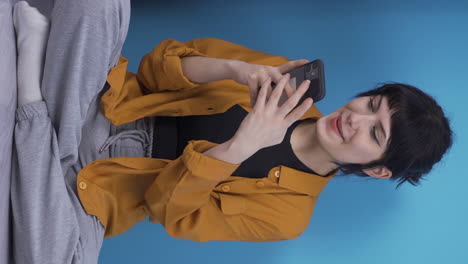Vertical-video-of-Young-woman-texting-with-happy-expression-with-her-boyfriend.
